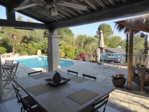 Eine Außenpatio mit Pool, Esstisch, Stühlen und einer Pergola.