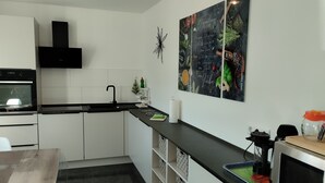 Una cucina moderna con mobili bianchi, un piano di lavoro nero e un forno a microonde.