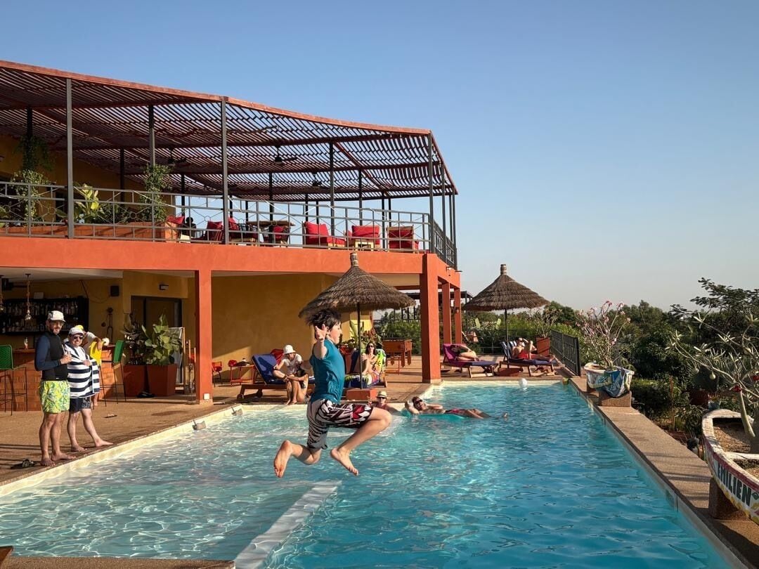 Una piscina al aire libre, sombrillas, sillones reclinables de piscina