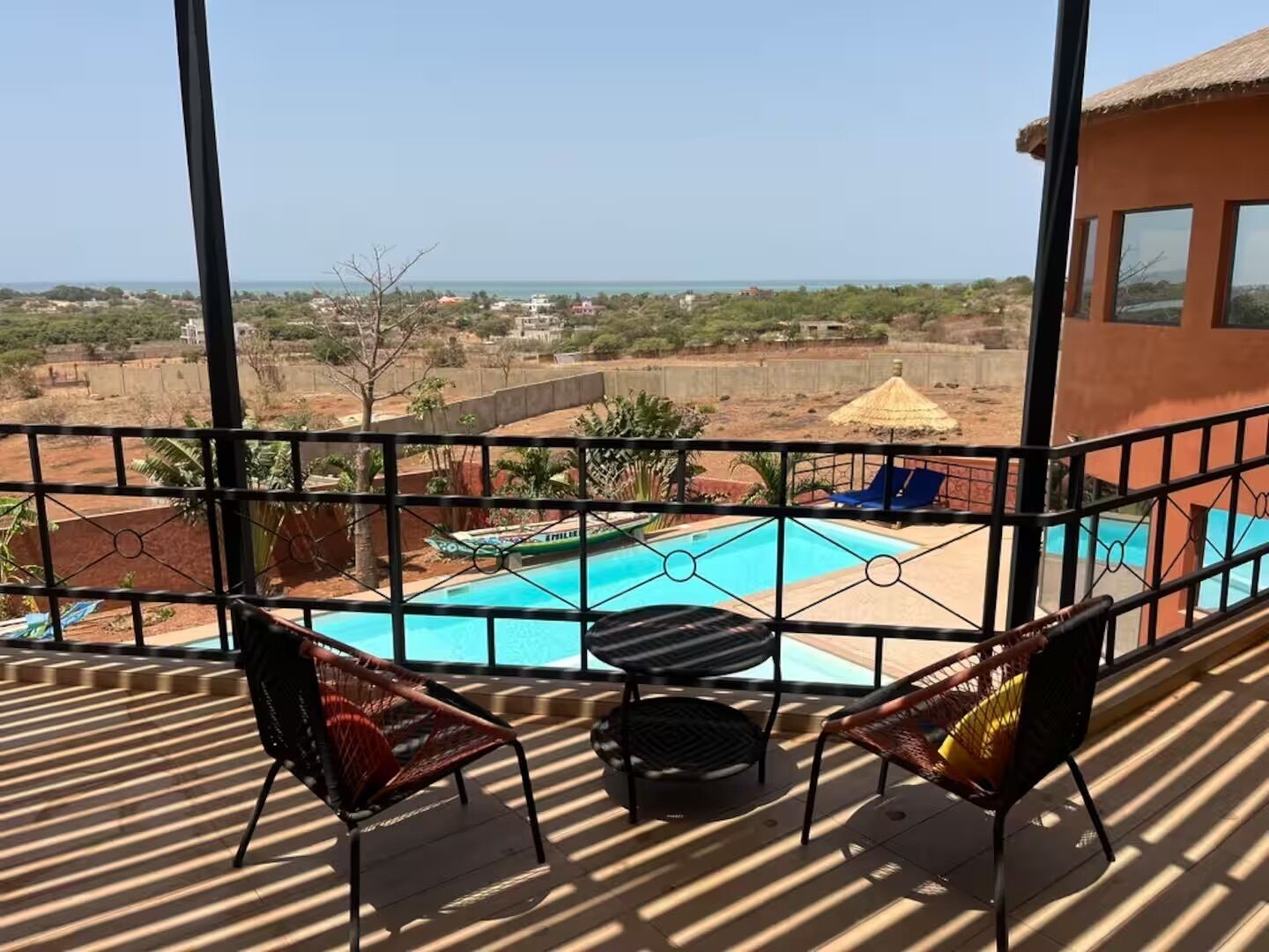 Un balcón con piscina, sillas y vistas al paisaje.