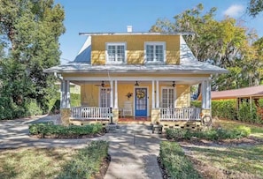A two-story house with a porch, a front door, and a small garden area. - McDonald Manor/Walk To DT Mt Dora/Boat Parking (Mount Dora)