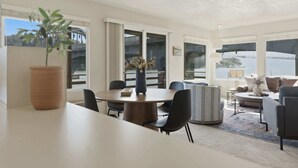 En modern inredning med ett matområde, sittplatser och stora fönster som erbjuder en fin utsikt.