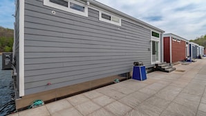 A row of mobile homes with a tiled patio area and a body of water. - Floatopia - A Unique Floating Retreat (Russell Springs)