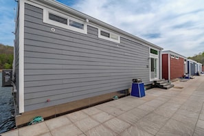 A row of mobile homes with a tiled patio area and a body of water.
