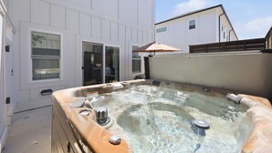 A hot tub in a backyard with a white house in the background. - Steps to Beach! Hot Tub, Dogs OK, Pool, Pickleball (Corolla)