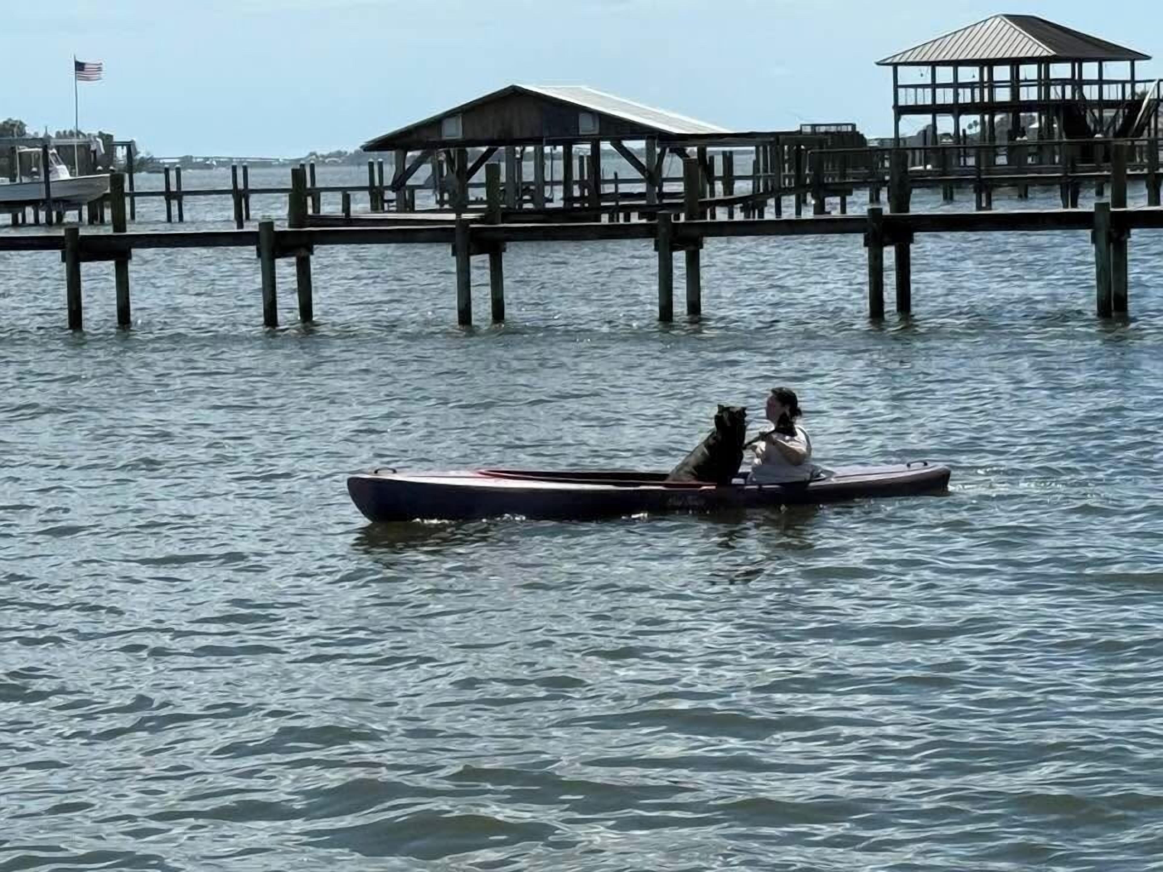 A pier extending into calm water with a covered structure at the end.