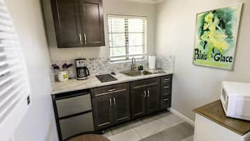 Suíte luxo, vista para o pátio | Cozinha privada | Micro-ondas, cooktop, talheres/pratos/utensílios de cozinha