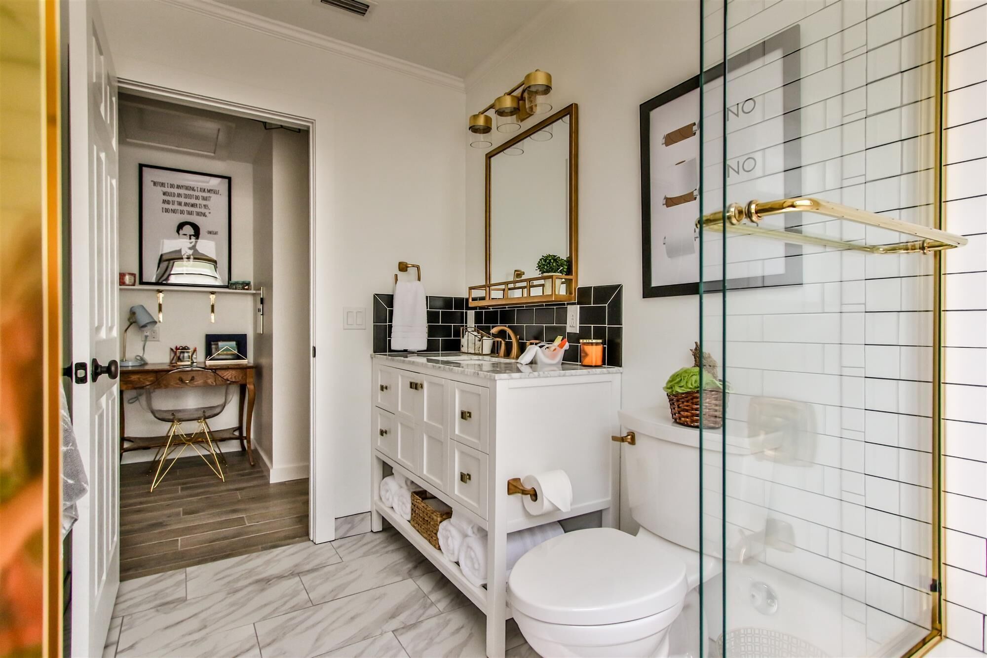 Ein Badezimmer mit Toilette, Waschbecken mit Spiegel und Duschbereich.
