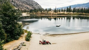 Um lago tranquilo com um barco, rodeado por montanhas e árvores.