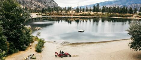 Un lago tranquilo con un bote, rodeado de montañas y árboles.