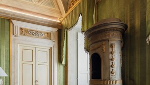 A room with a fireplace, green walls, and a tiled floor. - Guelfa 19 - (2) - One Bedroom Apartment, Sleeps 2 (Cortona)