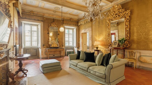 A spacious living room with a large sofa, ornate mirrors, and a chandelier. - Guelfa 19 - (1) - Two Bedroom Apartment, Sleeps 4 (Cortona)