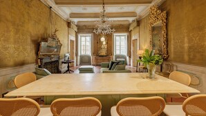 A formal dining room with a large table, chairs, a chandelier, and ornate decor. - Guelfa 19 - (1) - Two Bedroom Apartment, Sleeps 4 (Cortona)