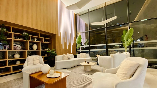 Ein modernes Wohnzimmer mit einer Couch, Sesseln, einem Couchtisch und einem Bücherregal.