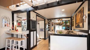 A kitchen with white cabinets, a marble countertop, and a hanging light fixture. - Private Pickleball Court + Riverfront Bend Retreat (Bend)