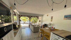 Una cocina compacta con lavadora, una zona de comedor con mesa y sillas, y vistas al exterior.
