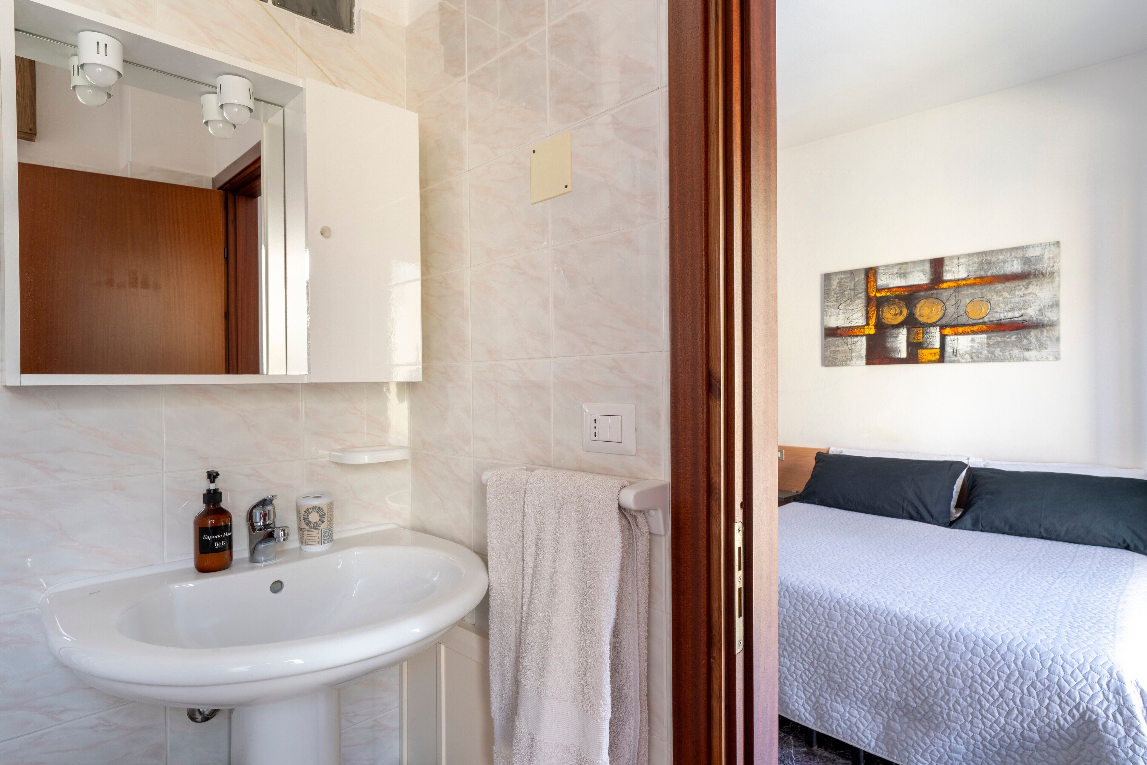 Une salle de bain équipée d’un lavabo, d’un miroir et d’un porte-serviettes.