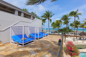 A resort with outdoor seating areas, a pool, and a view of the ocean. - Beach Villas at Divi Phoenix, Oceanview, Full Kitchen (Oranjestad)
