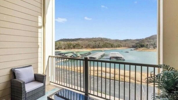 Ein Balkon mit Blick auf einen Fluss, angestellte Boote und eine hügelige Landschaft.