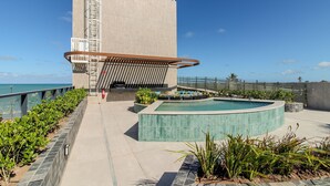 Ein modernes Gebäude mit Pool, Metalltreppe und Meerblick.