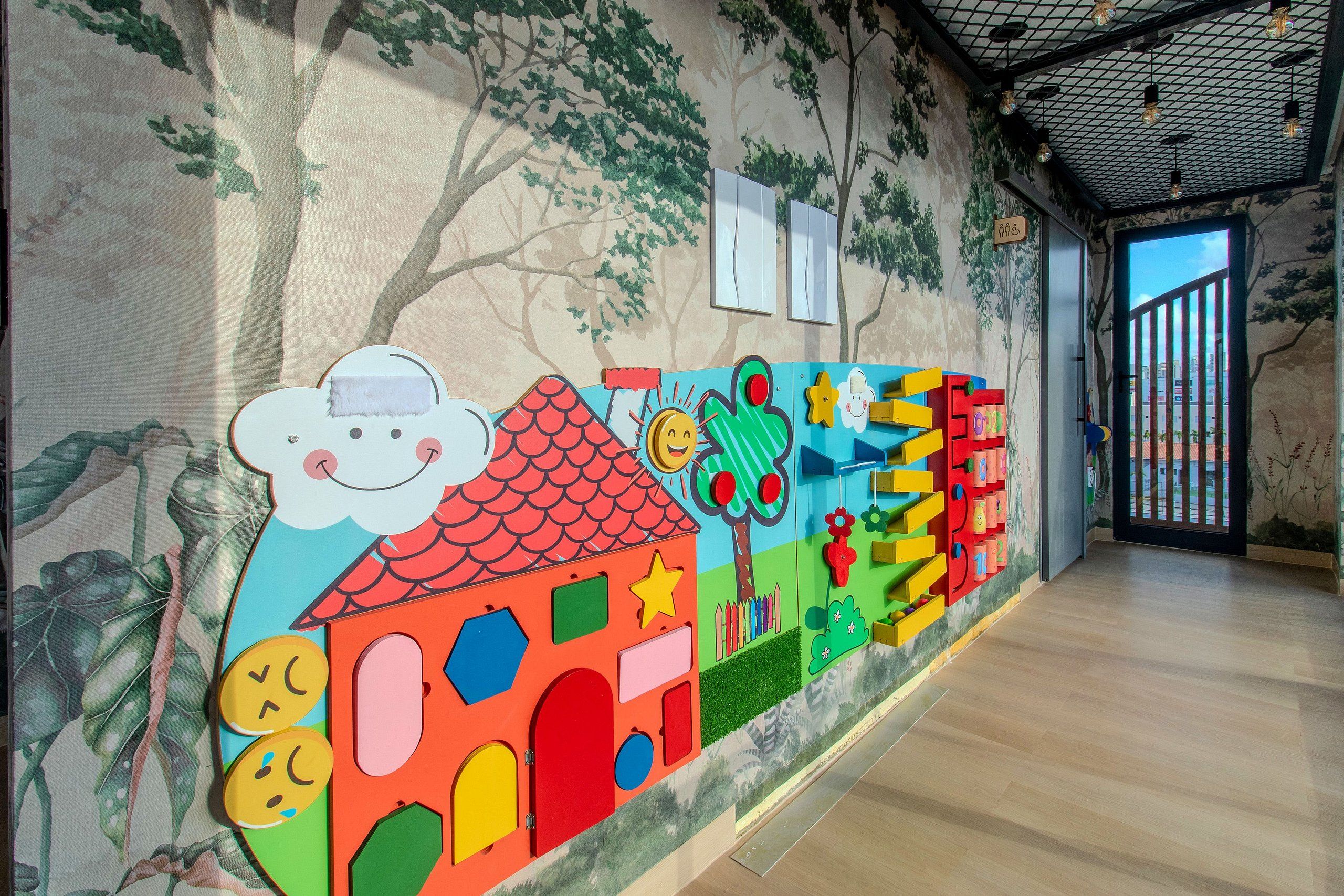 A hallway with a colorful mural, wooden flooring, and a view of the outdoors.