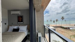 Un balcón con vista a la playa y palmeras.
