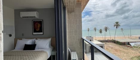 Un balcón con vista a la playa y palmeras.