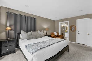 A bedroom with a bed, nightstands, a chair, a door, and a mirror. - Park City Walk to Hiking & Canyons Golf | Pool (Park City)