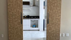 Una cocina moderna con armarios blancos, una campana extractora de acero inoxidable y una estufa a gas.