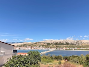 Eine Küstenstadt mit Blick auf das Meer und die dahinterliegenden Berge.