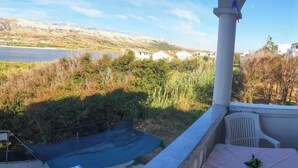 Ein Balkon mit Blick auf einen See, ein Stuhl und ein Tisch.