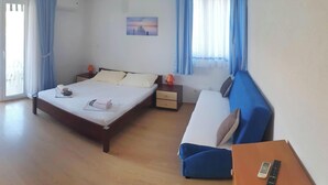 Ein Hotelzimmer mit Bett, Sofa, Nachttisch, Lampe und einem Gemälde an der Wand.