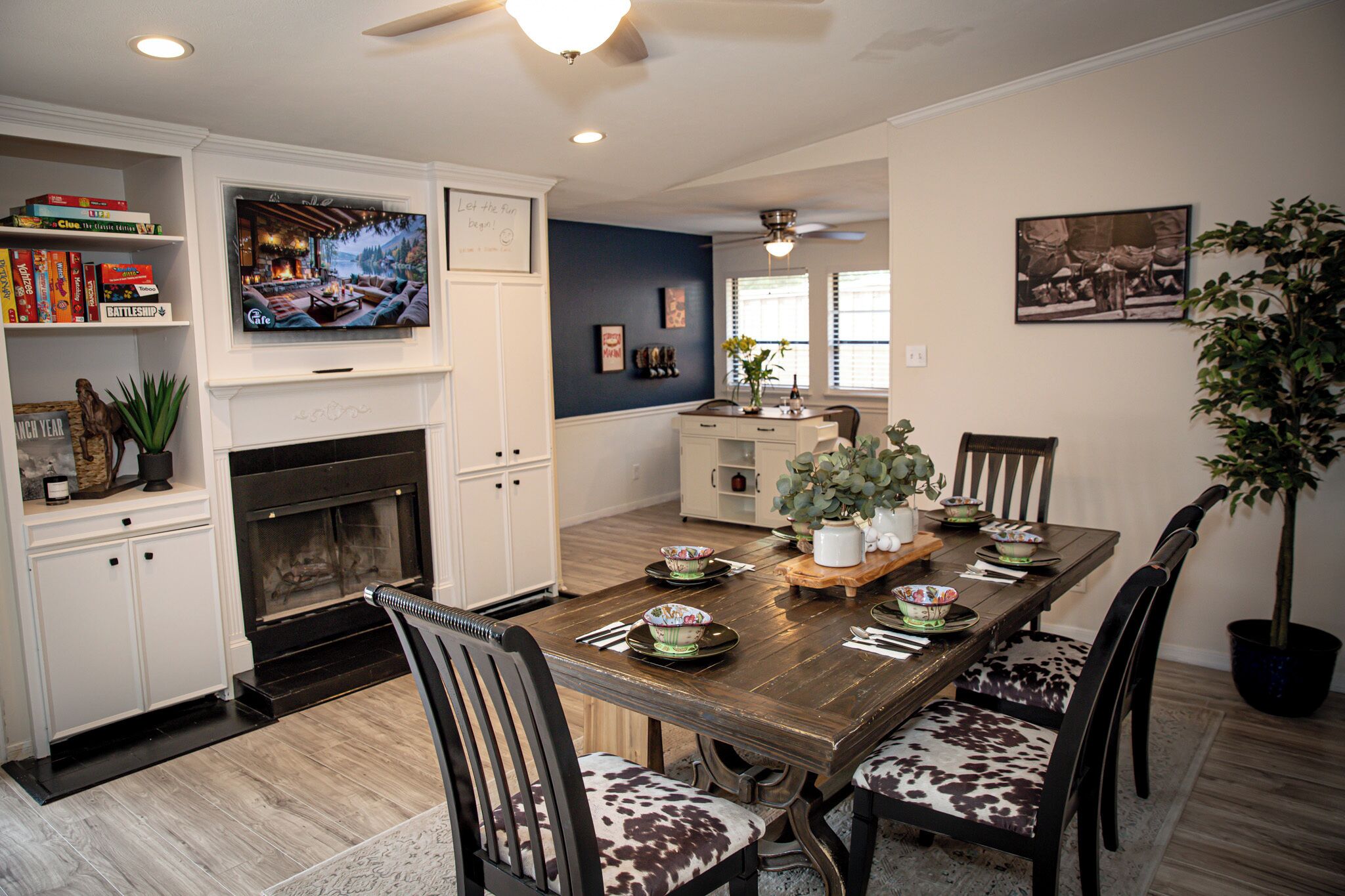 A dining area with a wooden table, chairs, and a fireplace.