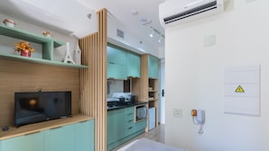 Una cucina moderna con TV a schermo piatto, pensili in legno e forno a microonde.