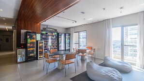 Un interno moderno con zona pranzo, distributori automatici e un'ampia finestra.