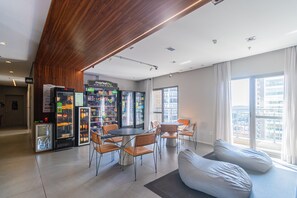 Ein modernes Interieur mit Essbereich, Verkaufsautomaten und einem großen Fenster.