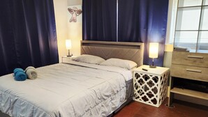 Una camera da letto con un letto, due comodini, una cassettiera e un quadro appeso al muro.