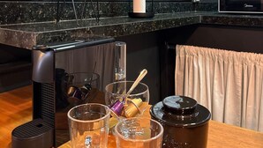 Eine Küchenarbeitsplatte mit einer Mikrowelle, einem Glasbehälter und einem Holztisch.