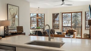 Una cocina moderna con una isla grande, un área de comedor con vistas y un espacio de descanso acogedor.