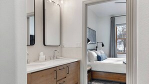 Un baño moderno con tocador, lavamanos y espejo.