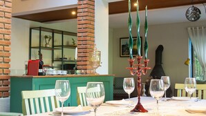 Un comedor con un arco de ladrillo, una mesa dispuesta para una comida y una araña.