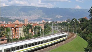 A train on tracks with a cityscape and mountains in the background. - Comfort and style in San Javier / 15min Comuna 13 (Medellín)