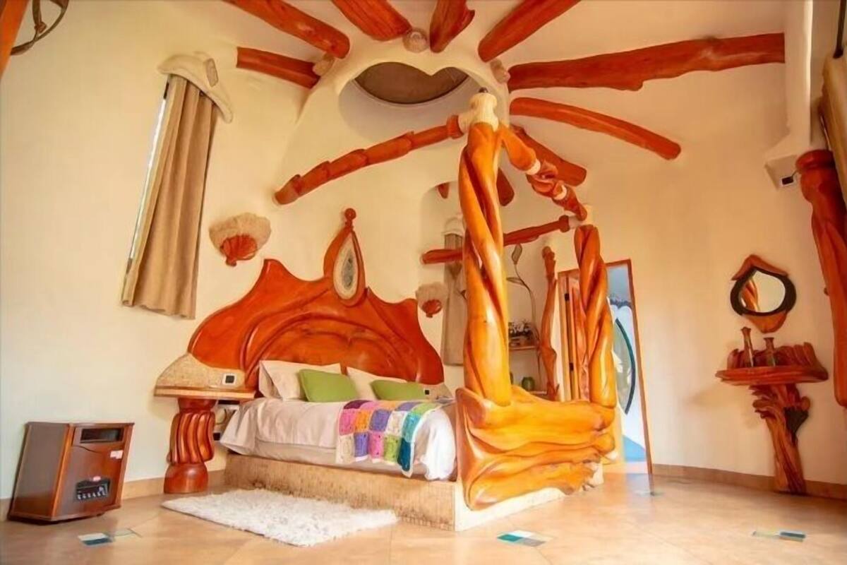 Un dormitorio con una cama de madera con dosel, una mesita de noche y una radio pequeña.