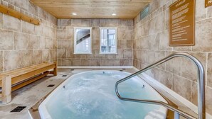 Ein Spa-Raum mit Whirlpool, Holzbänken und gefliesten Wänden.
