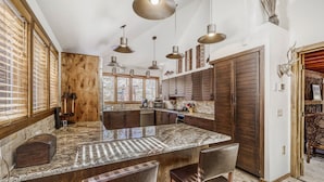 A spacious kitchen with a large island, wooden cabinetry, and pendant lighting. - New Listing! Hot Tub, Sauna, Your Family Mountain Home Getaway! (Keystone)