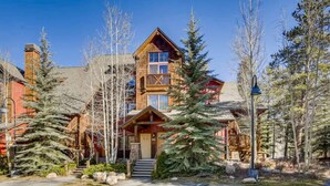 A lodge with a prominent wooden facade, a balcony, and a staircase leading to the entrance. - Fun and Relaxation in a Mountain Vacation Getaway! (Keystone)