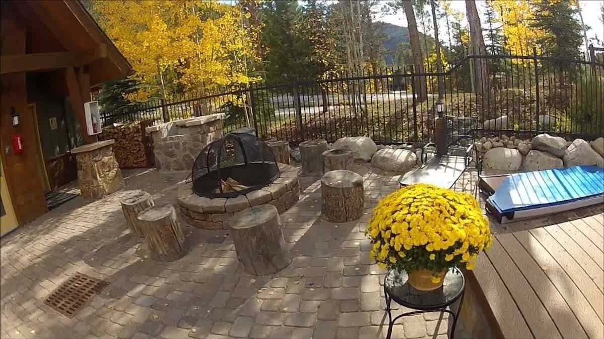 An outdoor patio with stone seating, a fire pit, and a flower arrangement.