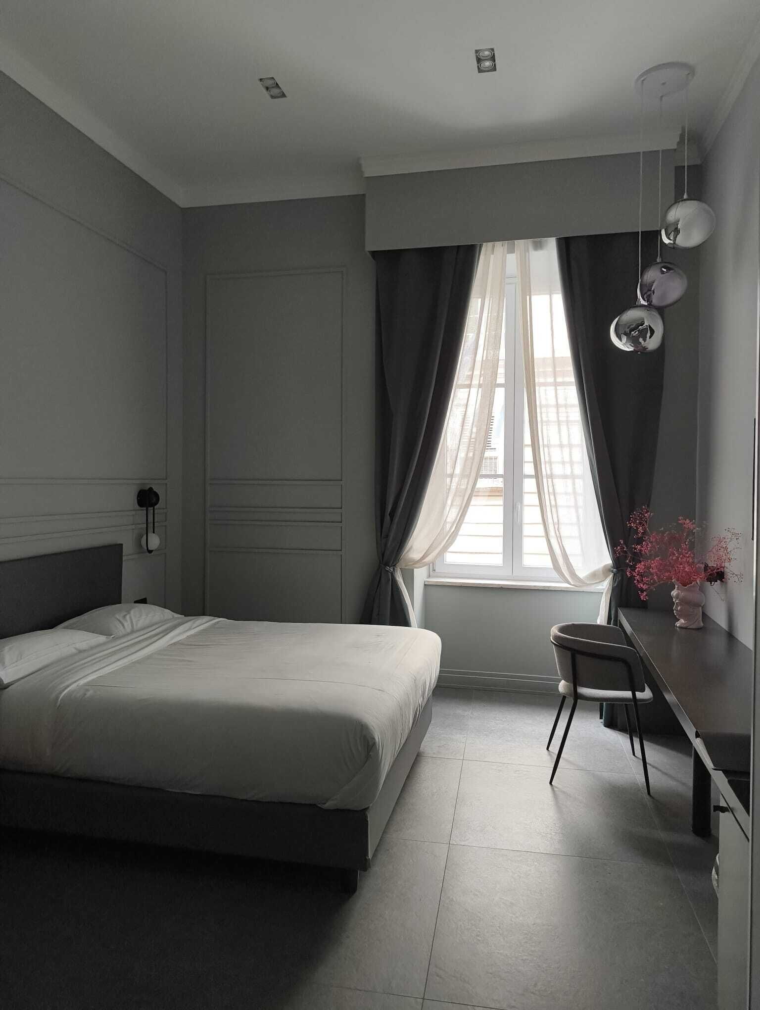 Quarto moderno com cama, escrivaninha e cadeira.