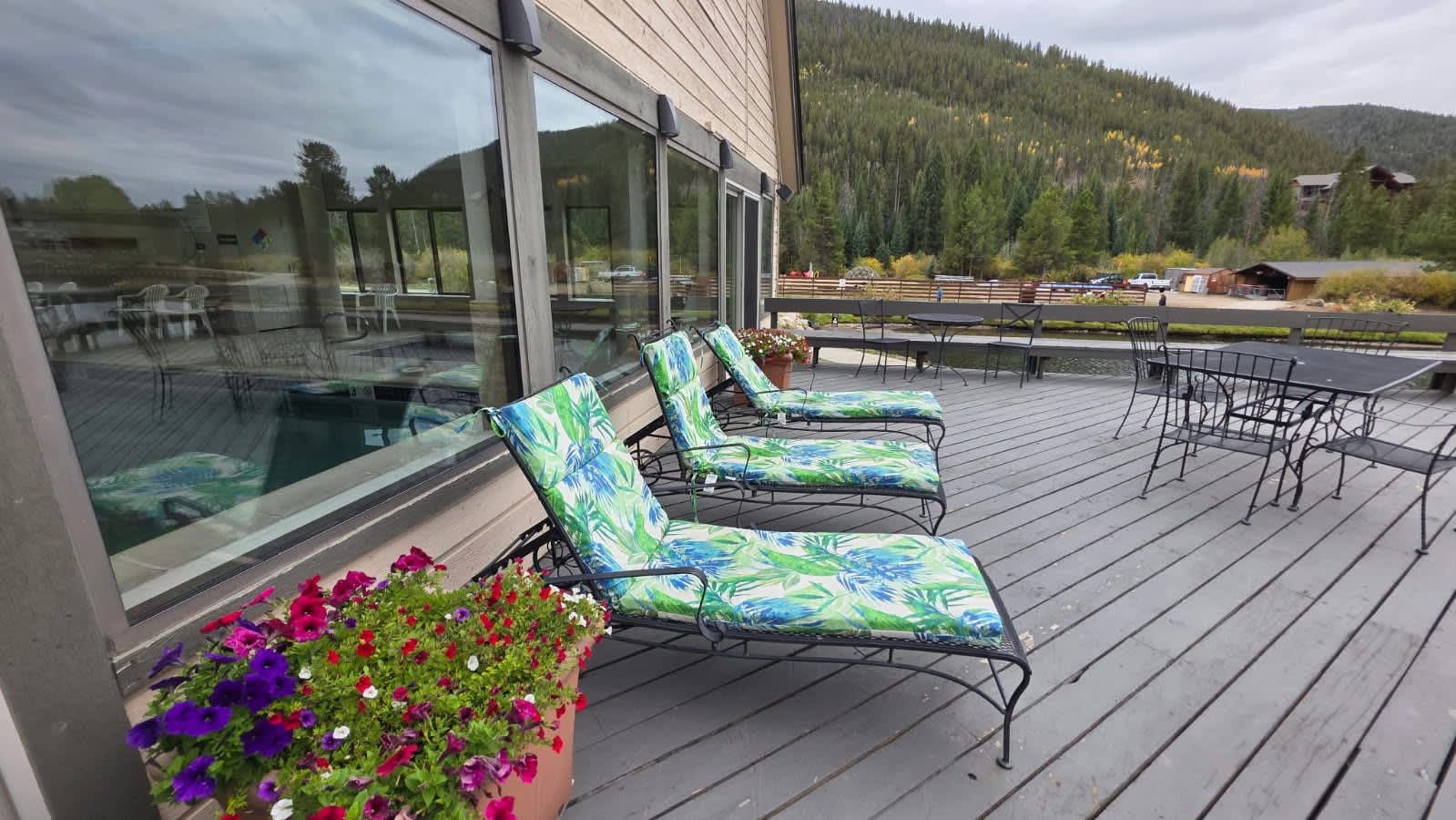 A deck with lounge chairs and a swimming pool.