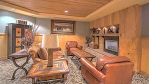 A cozy living room with leather sofas, a fireplace, and a large window. - Heart of River Run Village! (Keystone)